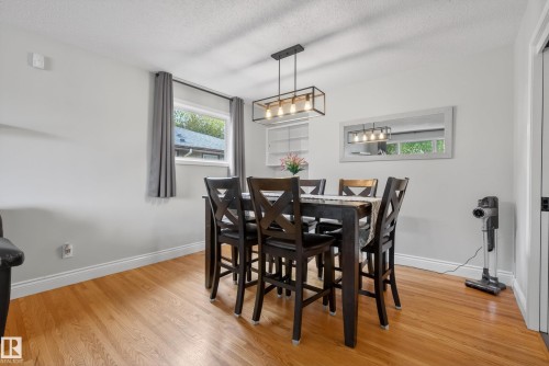 Dining area featuring wood-finish flooring, white baseboards, and light gray walls - 16105 109A Avenue, Edmonton, AB 
