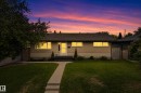 Exterior featuring a concrete walkway, established lawn, mature landscaping, and a front entry with a storm door - 16105 109A Avenue, Edmonton, AB 