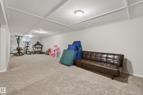 Spacious room featuring light-colored carpeting, white walls, and a dropped ceiling with integrated lighting - 16105 109A Avenue, Edmonton, AB 
