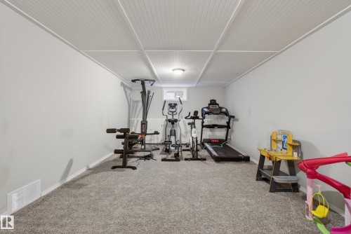 Spacious carpeted room with light grey walls and a white beadboard ceiling - 16105 109A Avenue, Edmonton, AB 