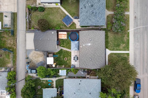 Spacious property featuring two structures with asphalt shingle roofing, a gravel driveway, and concrete walkways - 16105 109A Avenue, Edmonton, AB 