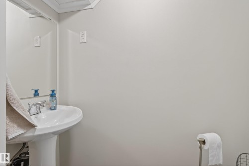 Pedestal sink with chrome faucet, complemented by a large wall-mounted mirror - 16105 109A Avenue, Edmonton, AB 