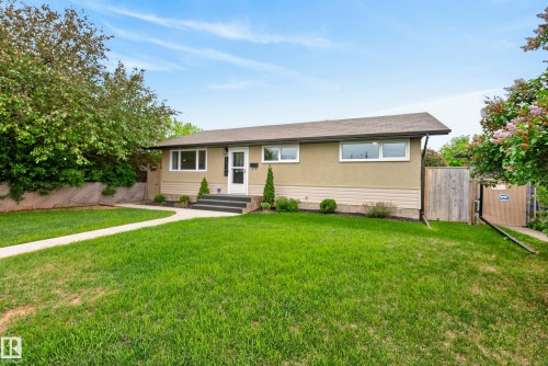 Single-story residence featuring a neutral stucco and siding exterior, a dark shingle roof, and white window frames - 16105 109A Avenue, Edmonton, AB 