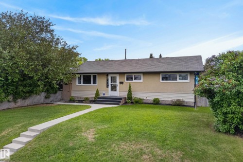 Exterior featuring a light stucco facade with white trim windows, a gray shingle roof, and a front entry with dark steps - 16105 109A Avenue, Edmonton, AB 