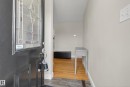 Entryway with wood-finish flooring, light grey wall paint, and a decorative frosted glass front door - 16105 109A Avenue, Edmonton, AB 