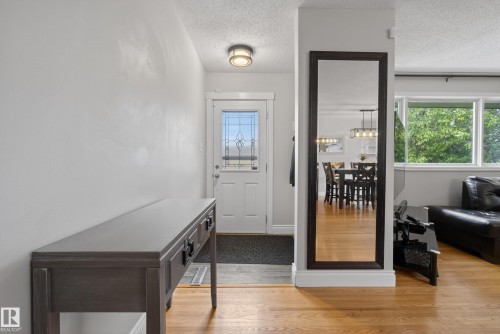 Entryway featuring hardwood flooring, a white front door with leaded glass insert, and a flush-mount ceiling light - 16105 109A Avenue, Edmonton, AB 