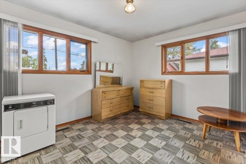 Room featuring two multi-pane windows with wood frames, a checkered floor pattern, and white painted walls - 12923 113A Street, Edmonton, AB 