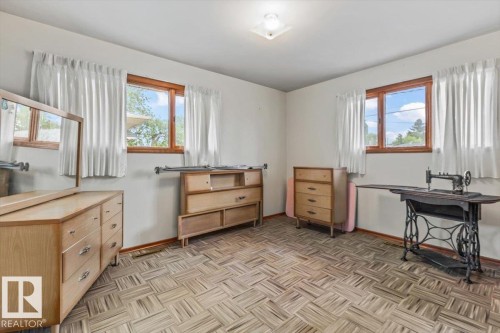 Spacious interior room featuring light-toned walls, wood-framed windows, and patterned flooring - 12923 113A Street, Edmonton, AB 