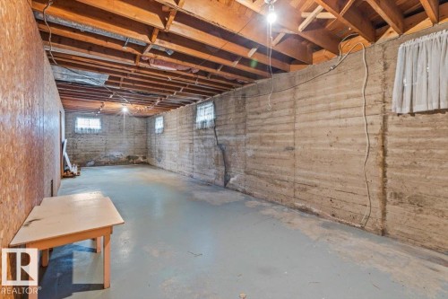 Exposed wood joists and subflooring define the ceiling of this spacious basement - 12923 113A Street, Edmonton, AB 