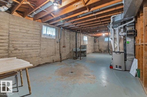 Expansive unfinished basement featuring concrete walls and exposed wood ceiling joists - 12923 113A Street, Edmonton, AB 
