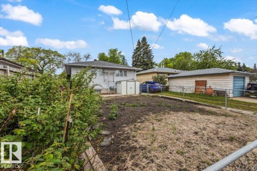 Expansive outdoor space featuring a detached garage, established perimeter plantings, and a functional storage shed - 12923 113A Street, Edmonton, AB 