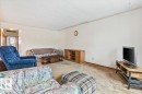 Living area featuring neutral wall tones, textured ceiling, and carpeting - 12923 113A Street, Edmonton, AB 