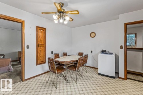 Compact dining area featuring patterned flooring, white walls, and a ceiling fan with integrated lighting - 12923 113A Street, Edmonton, AB 