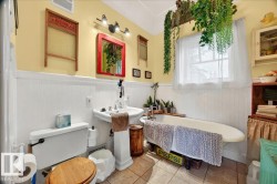 Pedestal sink and freestanding bathtub with an overhead window - 