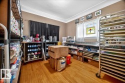 Spacious room featuring hardwood flooring, crown molding, and two windows providing natural light - 