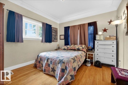 Hardwood flooring featuring a window with natural light, crown molding, and neutral wall tones - 572004 Highway 857, Rural Two Hills County, AB 