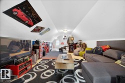 Spacious finished attic space featuring sloped ceilings, a window dormer, and recessed lighting - 