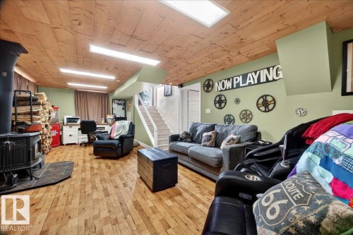 Spacious lower-level living area featuring wood-finish flooring and a wood-paneled ceiling - 572004 Highway 857, Rural Two Hills County, AB 