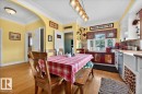 Dining area featuring wood-finish flooring, an arched doorway, and a linear pendant light fixture - 572004 Highway 857, Rural Two Hills County, AB 