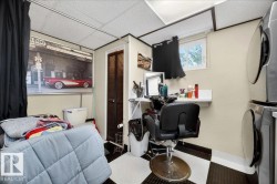 Compact utility space featuring a window, built-in shelving, checkered floor tiling, and a louvered door - 