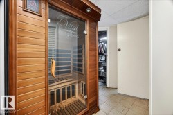 Built-in sauna with wood paneling and a clear glass door - 