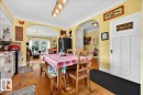 Dining area with wood-finish flooring, featuring an arched entryway, a built-in light fixture, and white trim - 572004 Highway 857, Rural Two Hills County, AB 