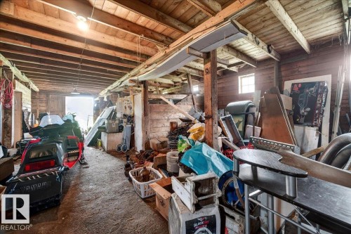 Rustic barn interior featuring exposed wood beams, wood paneling, and visible rafter ceiling - 572004 Highway 857, Rural Two Hills County, AB 