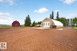 Large Quonset hut structure featuring multiple bay doors and an exterior stairway - 