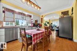 Kitchen featuring wood-finish flooring, white cabinetry, and stainless steel appliances - 