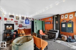 Utility room with a wood-burning stove, white and orange painted walls, and concrete flooring - 