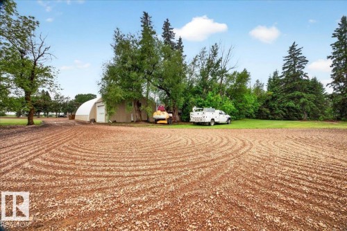 Expansive gravel area with distinct circular patterns, bordered by a substantial grass expanse - 572004 Highway 857, Rural Two Hills County, AB 