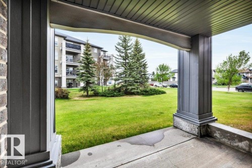 Covered concrete patio with a structured pillar and brick facade - 116 630 Mcallister Loop, Edmonton, AB 