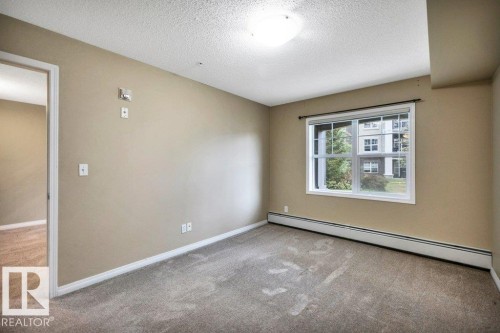 Neutral-toned walls complement the gray carpeting - 116 630 Mcallister Loop, Edmonton, AB 