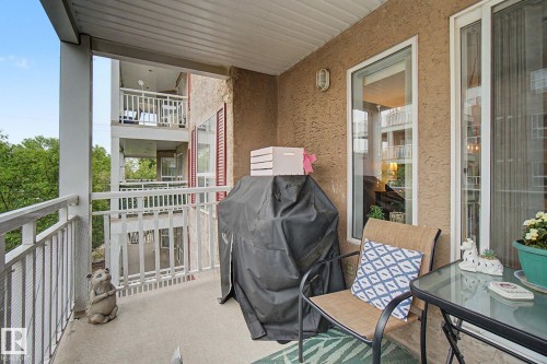 Balcony featuring a textured stucco exterior, white railing, and a durable concrete floor - 308 10933 124 Street, Edmonton, AB 