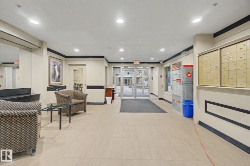 Entryway featuring light-toned tile flooring, recessed lighting, a glass-paneled entrance door, and a wall-mounted mailbox system - 308 10933 124 Street, Edmonton, AB 