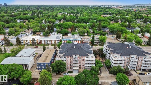 Multi-story building featuring private balconies, dark shingle roofing, and a light-toned facade - 308 10933 124 Street, Edmonton, AB 
