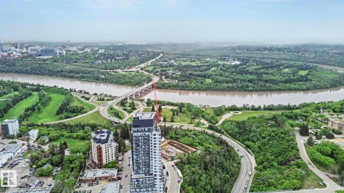 Expansive aerial perspective showcasing a riverine landscape bordered by dense green foliage - 308 10933 124 Street, Edmonton, AB 