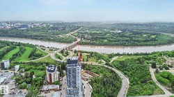 Expansive aerial perspective showcasing a riverine landscape bordered by dense green foliage - 