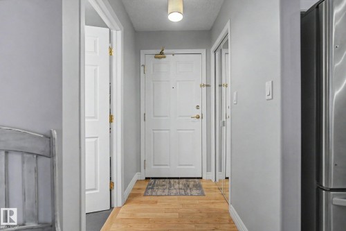 Entryway featuring wood-finish flooring, light grey walls, and a recessed ceiling light fixture - 308 10933 124 Street, Edmonton, AB 