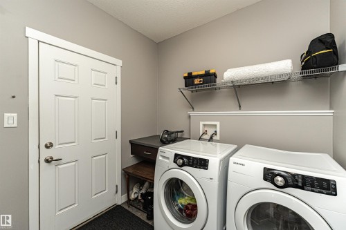 Laundry area featuring a paneled door, neutral wall color, and white trim - 115 57 Street, Edmonton, AB 