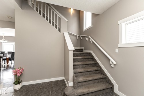 Carpeted staircase with white handrails and balusters - 115 57 Street, Edmonton, AB 