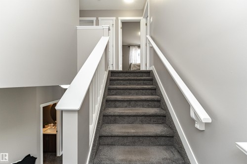 Carpeted staircase with white balusters and handrails - 115 57 Street, Edmonton, AB 