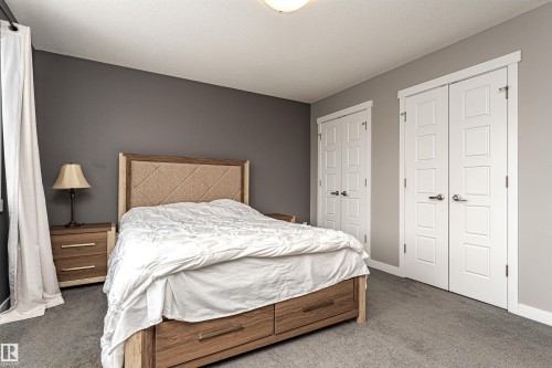 Carpeted room with neutral walls, recessed lighting, and two sets of white paneled double doors - 115 57 Street, Edmonton, AB 