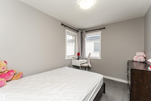 Room featuring neutral gray walls, dark carpet, and white trim - 115 57 Street, Edmonton, AB 