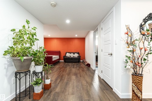 Finished lower level featuring wood-finish flooring, recessed lighting, and a vibrant accent wall - 115 57 Street, Edmonton, AB 