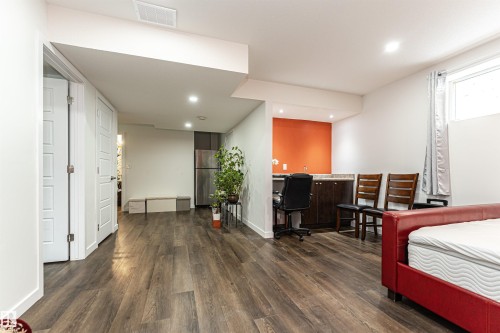 Spacious room featuring wood-finish flooring, recessed lighting, and white panel doors - 115 57 Street, Edmonton, AB 