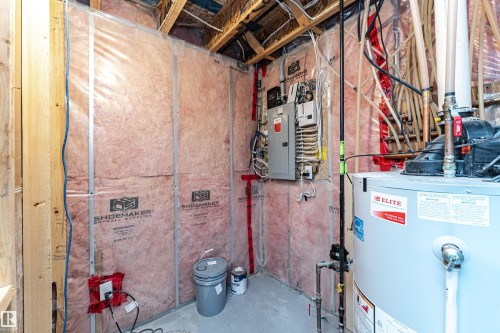 Utility area featuring a water heater, electrical panel, exposed ceiling joists, and insulated walls - 115 57 Street, Edmonton, AB 