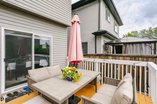 Wood-finish deck with white railings and gray vinyl siding - 115 57 Street, Edmonton, AB 