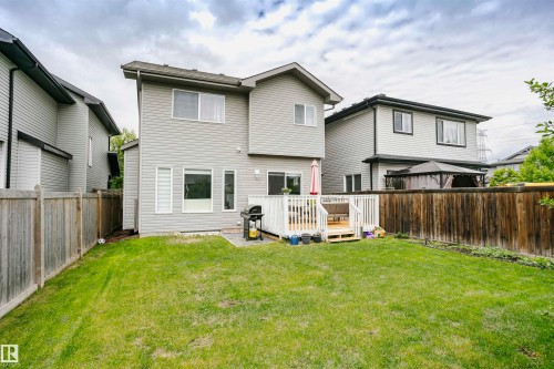 Expansive green lawn with a white wooden deck and privacy fencing - 115 57 Street, Edmonton, AB 
