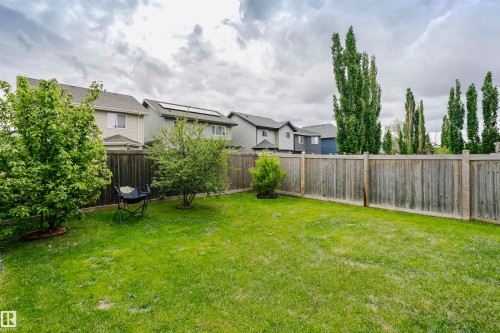 Spacious backyard featuring a manicured lawn, established landscaping, and a wood privacy fence - 115 57 Street, Edmonton, AB 